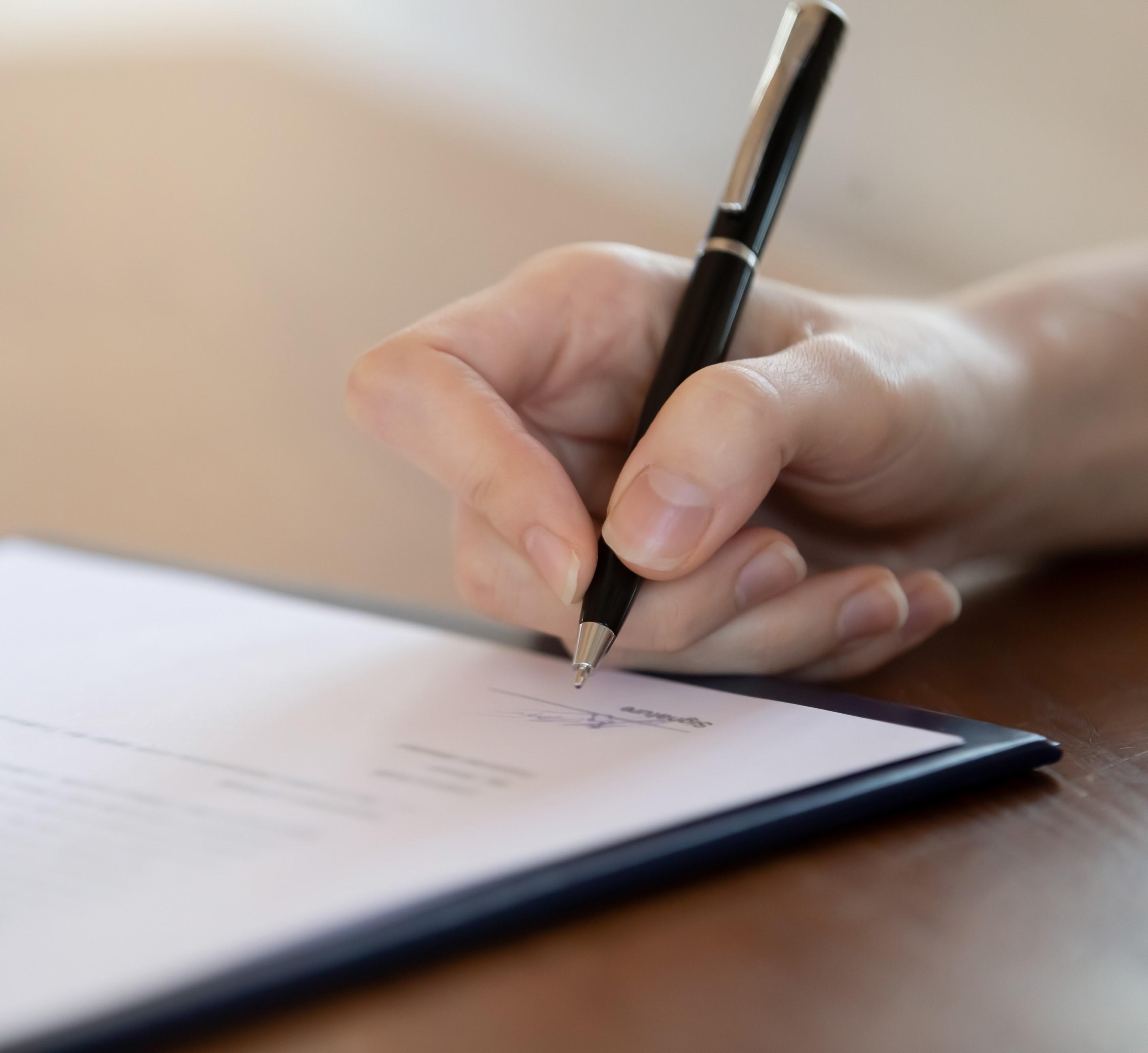Main signant un document.
